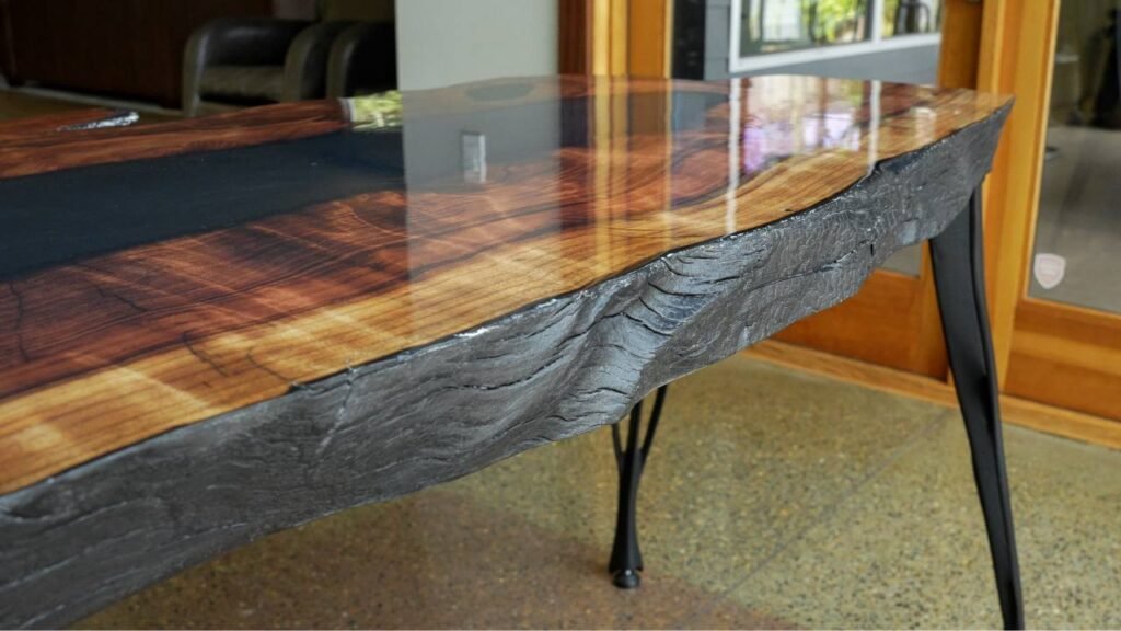 Slab table made from redwood with charred edges and black epoxy.