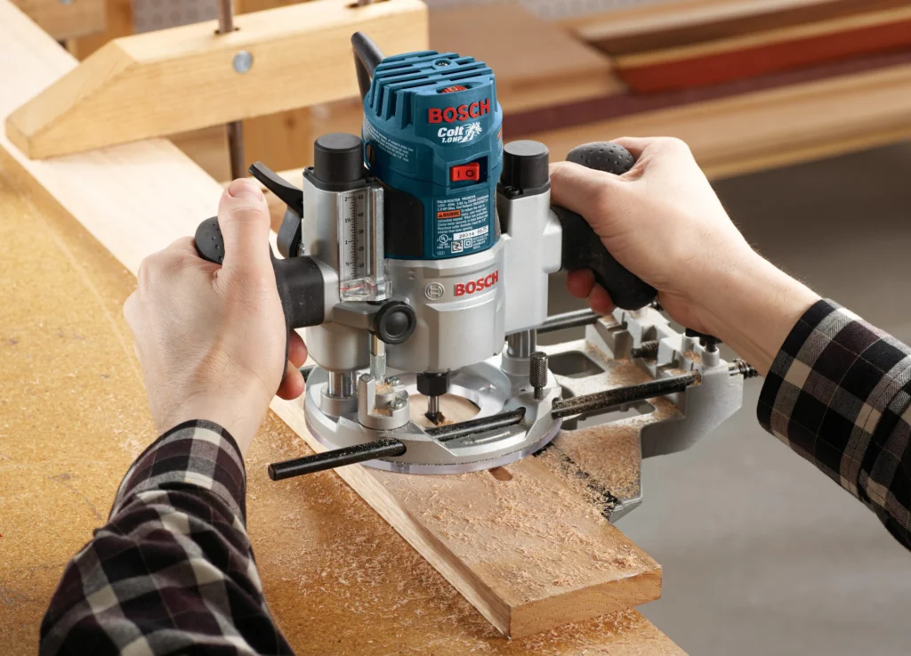 Bosch Colt plunge router in action routing a groove in a wooden board during woodworking
